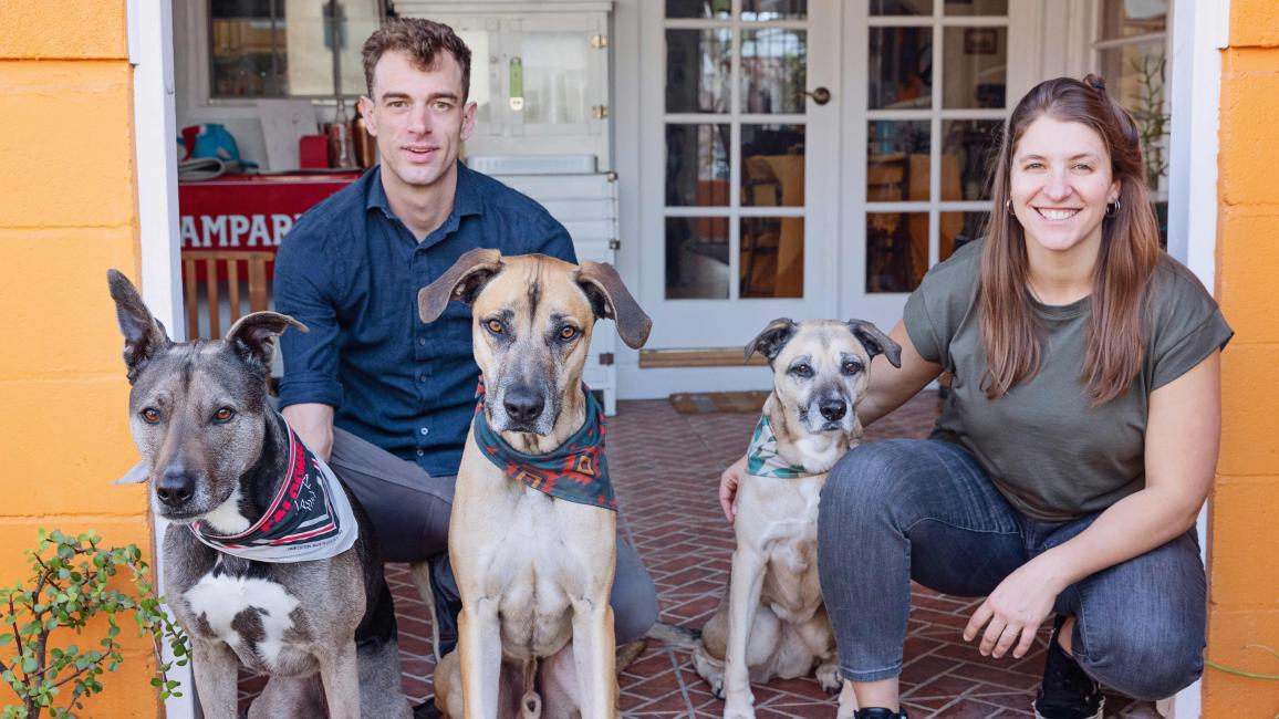 Peter the dog with his new family (including two other dogs), all on a front porch of a home