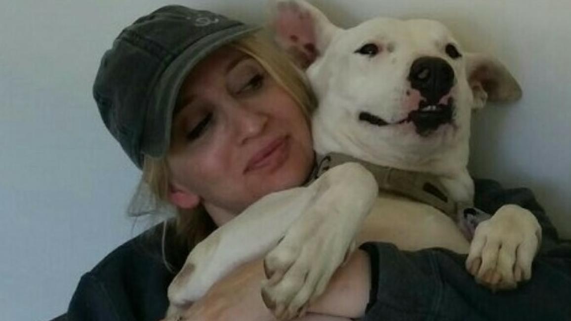Volunteer Sam snuggling with a white dog