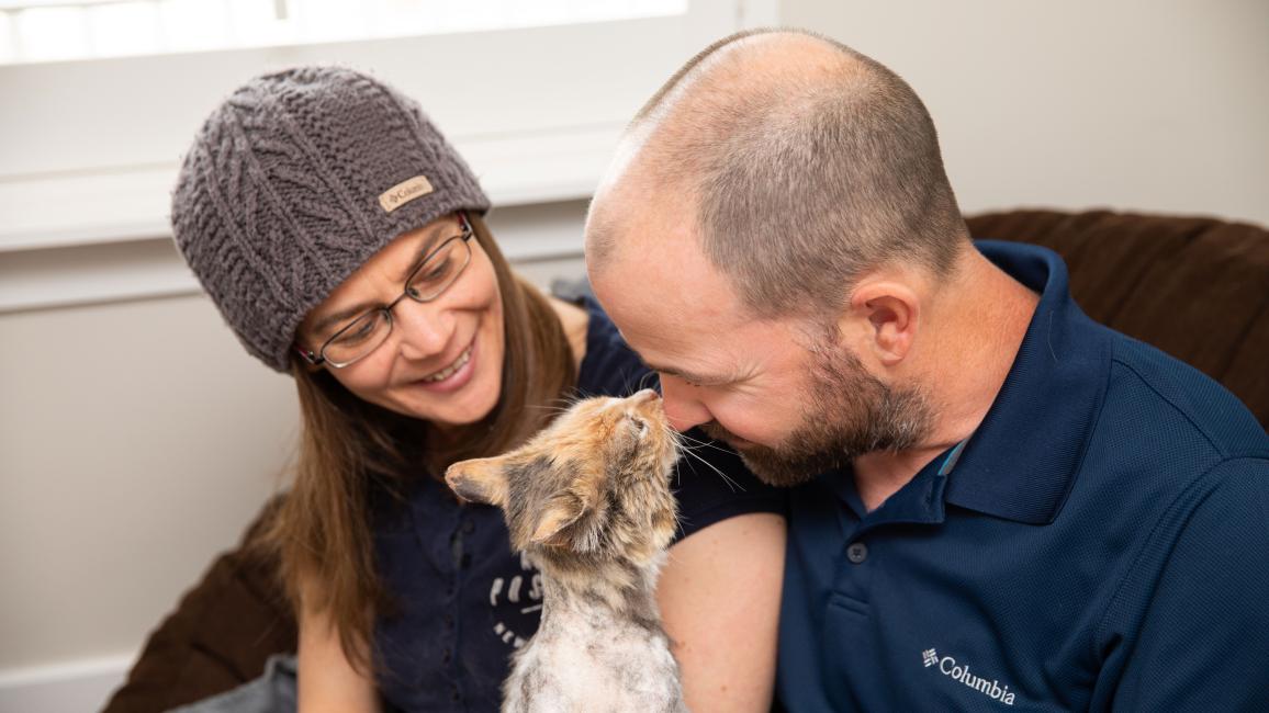 Alida and Gary Oldham with Cleopatra the cat, who is nose-to-nose with Gary