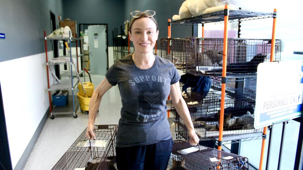 Kelly holding two live traps containing cats