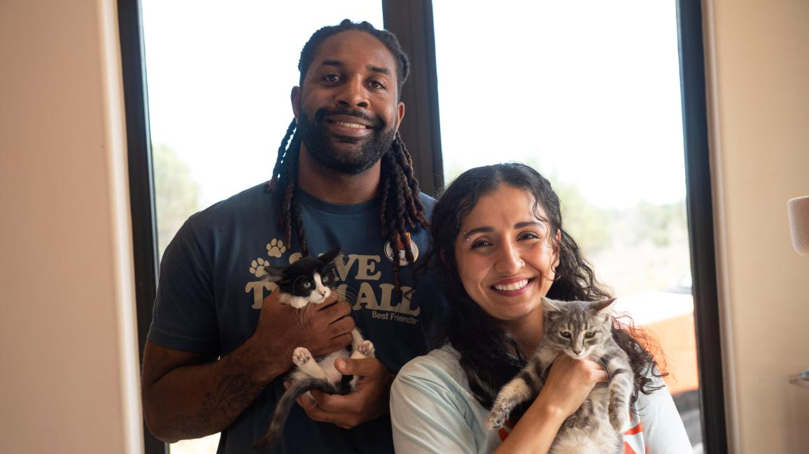 Abdul and Shamiyan holding kittens in front of a window