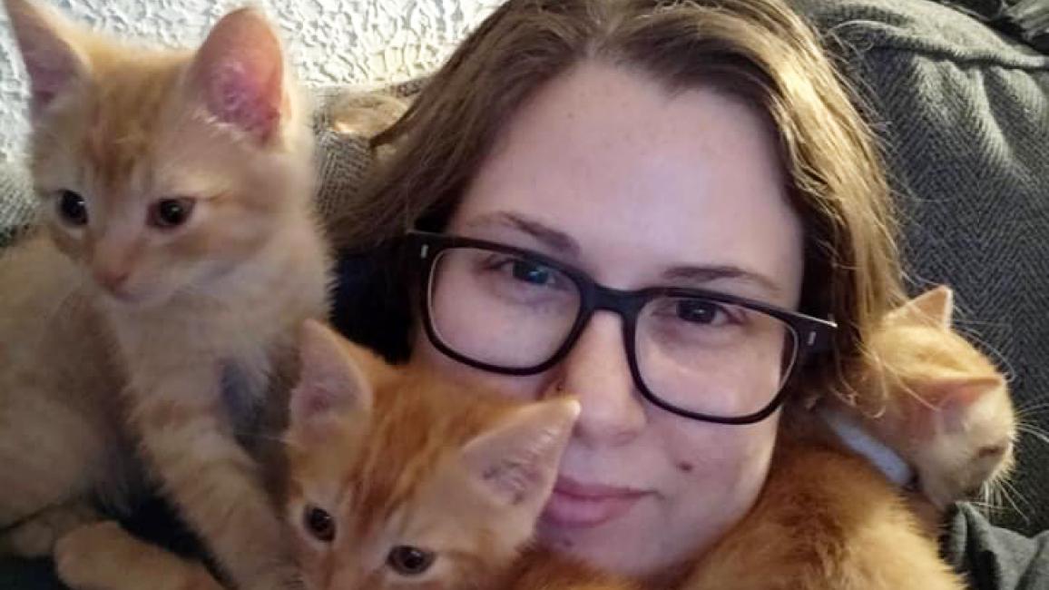 Jennifer Ronzello with three orange kittens surrounding her face