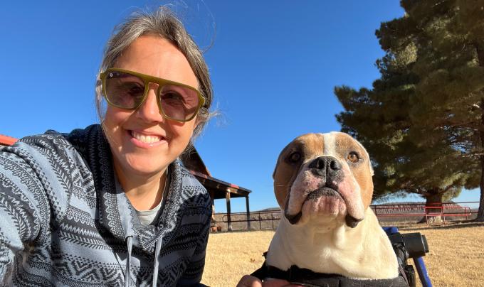 Heather Hall outside with a dog who is in a wheelchair
