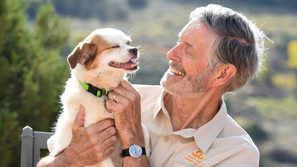 Gregory Castle smiling and holding a small dog