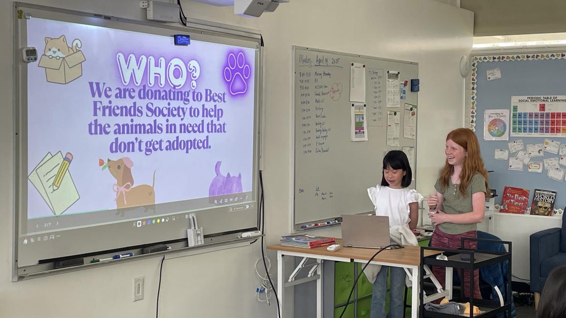 Students at Crestview Preparatory School beside a slide noting Best Friends as receiving donations