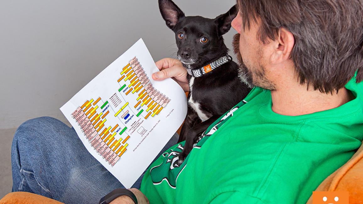Man wearing a green shirt with a small dog