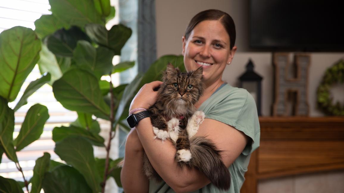 Chelsea holding Mirage, the miracle kitty, at her home