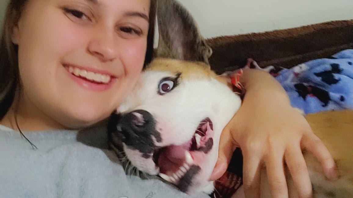 Selfie of Kylie LaVigne hugging Koda the dog