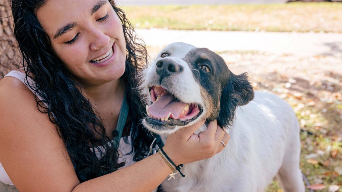 Smiling person holding the happy dog she adopted