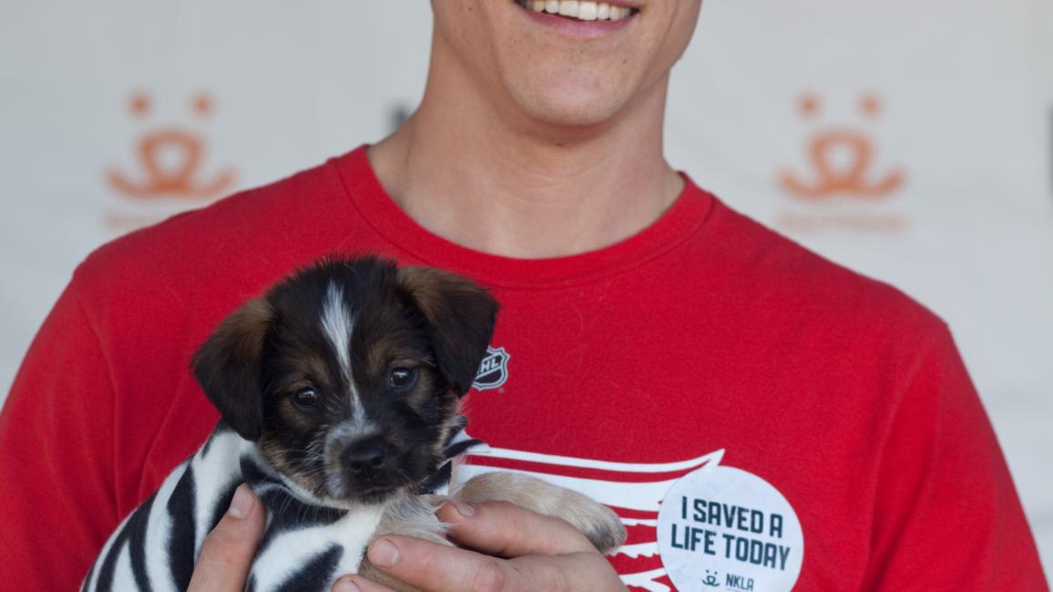 Man holding his adopted dog at the NKLA Adoption Weekend