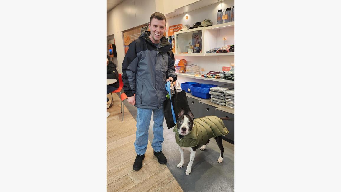 Jack Dugan with Lucky Charm the dog, who is wearing a green jacket