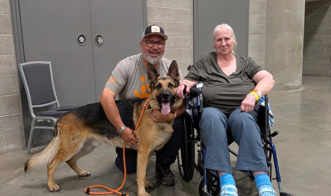 Donna in a wheelchair beside Shadow the dog and Best Friends staffer Timothy Perciful