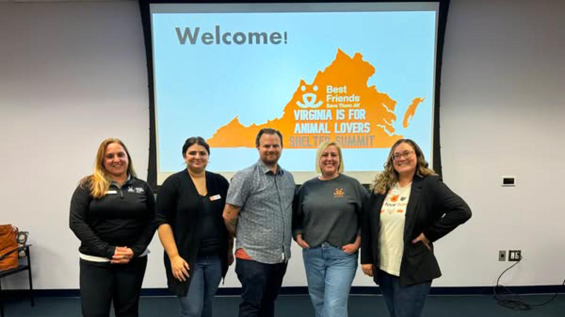 Virginia Is for Animal Lovers Shelter Summit team in front of a welcome slide on the wall