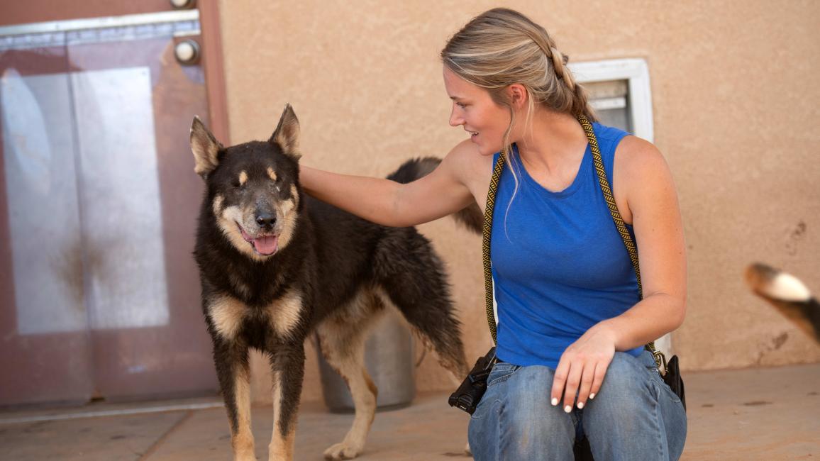Anna the caregiver petting Woody the dog