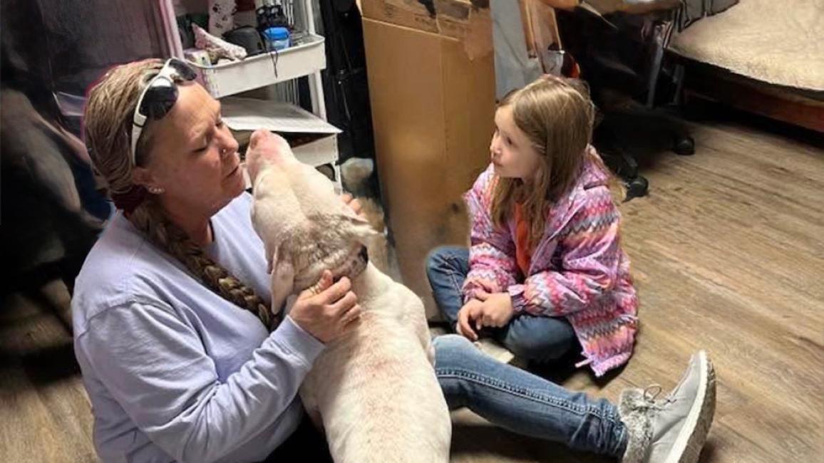 Melissa “Missy” Kidwell and child sitting on the floor with a dog