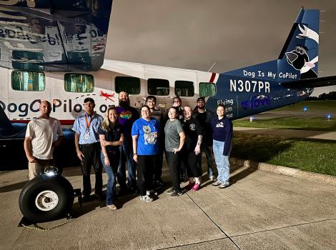 Group of people beside a Dog is My Co-Pilot plane