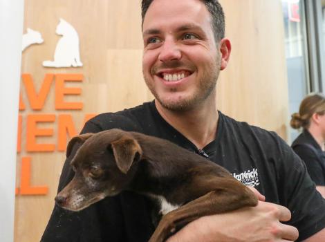 Alex Bowman smiling and holding a small dog