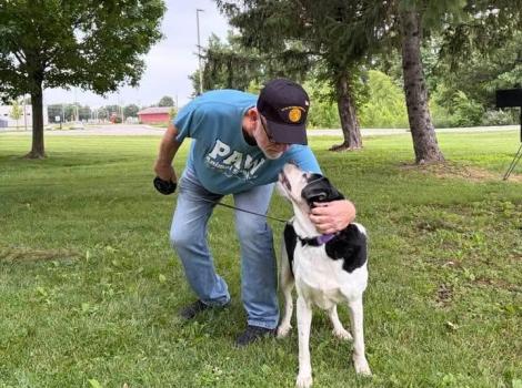 Anastasia the dog and her adopter, who is giving her a hug