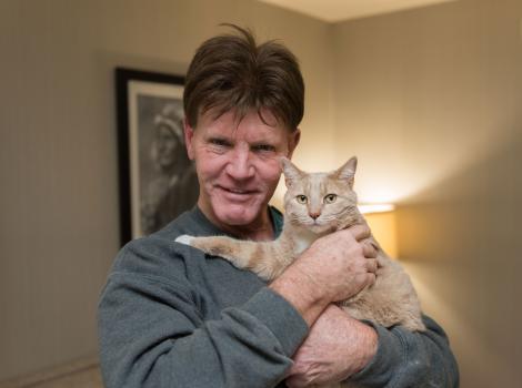 Volunteer Bill Coaker holding Rio the cat