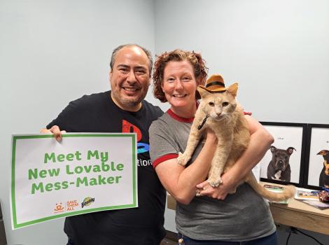 Nancy Stewart and Juve Vique adopting Banjo the cat, who is wearing his hat