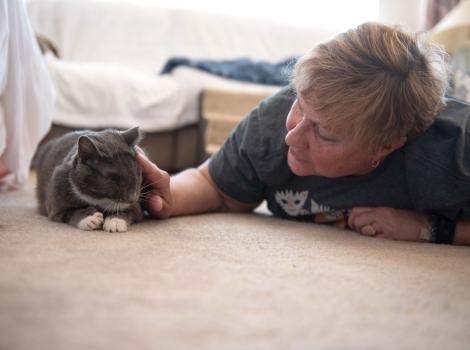Person lying on the floor next to Gia the cat
