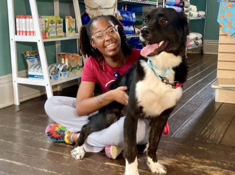 K’Terra sitting on the ground with a dog