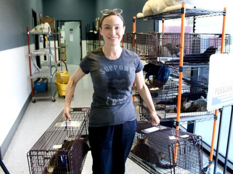 Kelly holding two live traps containing cats