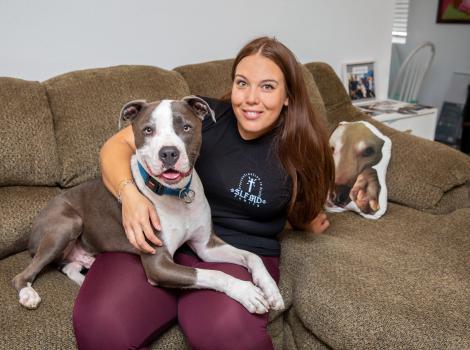 Woman with Neville the dog in her lap on a couch