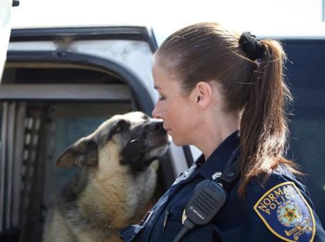 Kellee Robertson wearing a police uniform beside a shepherd dog