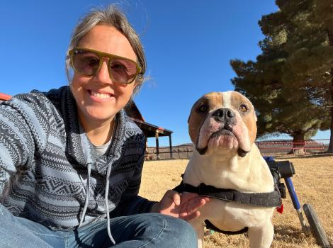 Heather Hall outside with a dog who is in a wheelchair