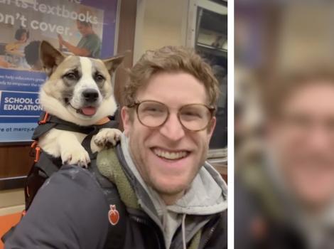 Bryan Reisberg smiling while carrying a dog in a backpack