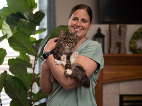 Chelsea holding Mirage, the miracle kitty, at her home