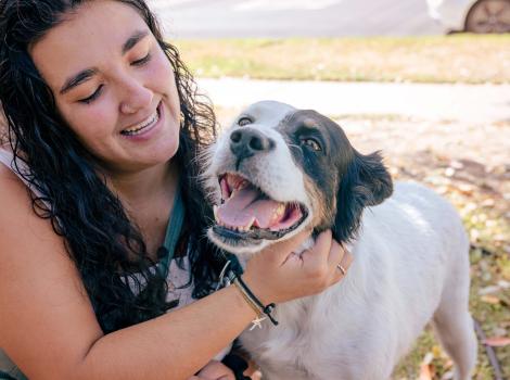Smiling person holding the happy dog she adopted