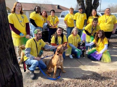 Group of people wearing yellow T-shirts with a brown dog