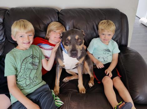 Sage the dog on a couch with three kids from the Brooks family