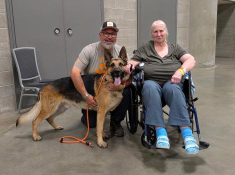 Donna in a wheelchair beside Shadow the dog and Best Friends staffer Timothy Perciful