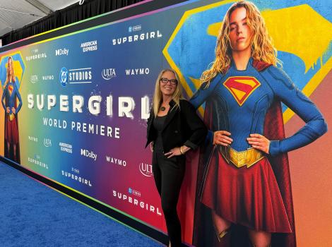 Best Friends CEO Julie Castle in front of a Supergirl world premiere sign