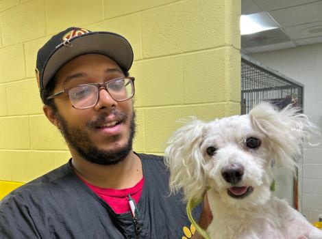 Trevor the groomer holding a small white dog