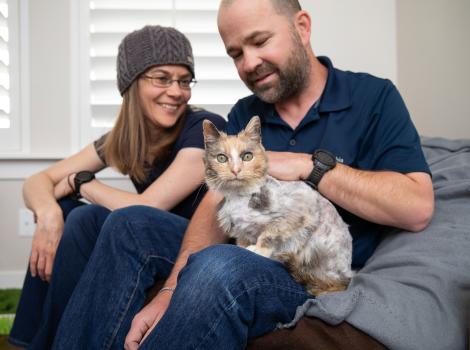 Alida and Gary sitting with a cat in his lap
