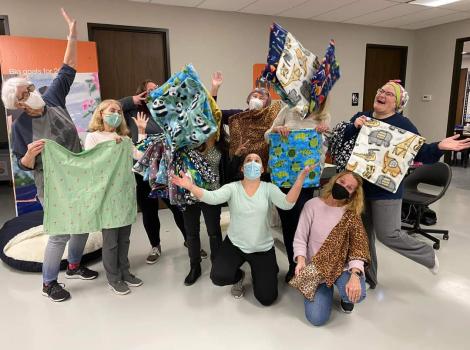 Group of volunteers holding the items they sewed for Best Friends