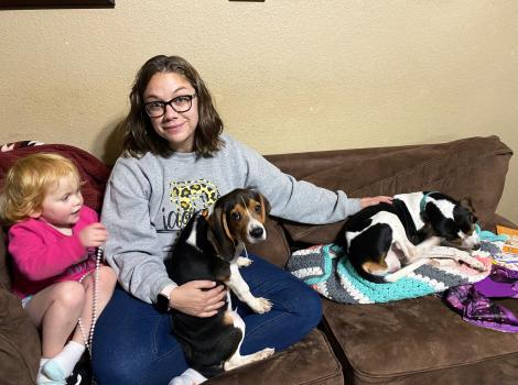Family sitting on couch with two beagles