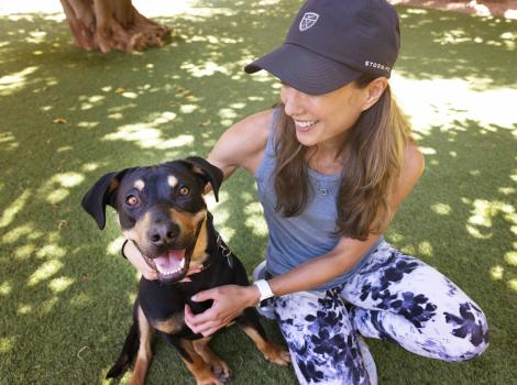 Diana Ross the dog, very happy outside with a person sitting next to her