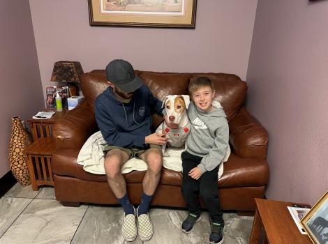 Mona the dog on a couch with her family